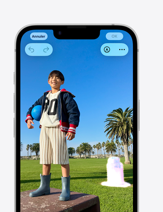 Écran d’iPhone, photo d’une personne souriant dans un parc, montrant comment effacer une poubelle en arrière-plan avec l’outil de nettoyage