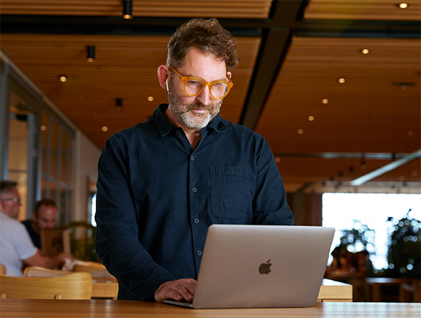 An Apple Corporate Functions team member using a MacBook in Caffè Macs.