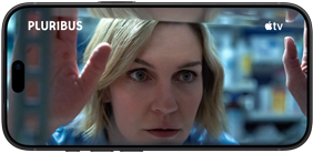 iPhone 18 Pro, οριζόντιος προσανατολισμός, που απεικονίζει ένα κοντινό πλάνο μιας γυναίκας που κοιτάζει μέσα από ένα ράφι. Τίτλος σειράς: Pluribus