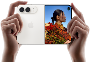 iPhone Duo, σε Λευκό του Άστρου, κρατιέται από δύο χέρια σε οριζόντιο προσανατολισμό, ξεδιπλωμένο, το αριστερό πλαίσιο δείχνει τις πίσω κάμερες Dual Fusion 48 MP, το δεξί πλαίσιο δείχνει ένα άτομο που το τραβούν φωτογραφία σε μια εξωτερική οθόνη, το άτομο μπορεί να δει το πρόσωπό του καθώς το τραβούν φωτογραφία με τη λειτουργία Duo Preview
