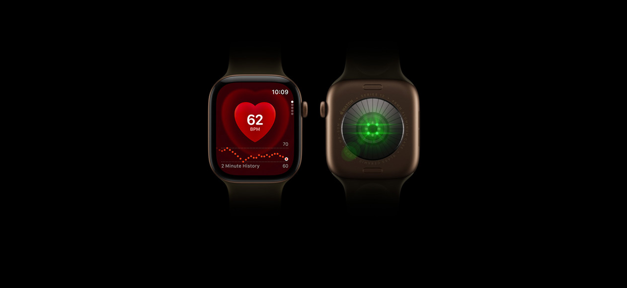 Deux Apple Watch Series 12, boîtier en aluminium, finition bronze sombre, Bracelet Sport olive, l’une est vue de face avec l’app Fréquence cardiaque à l’écran, l’autre est vue de dos, révélant le Système de suivi de santé et l’éclat de ses LED vertes