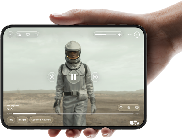 iPhone&nbsp;Duo, tiek turēts vienā rokā, atvērts horizontālā novietojumā, pilnībā atvērts, iekšējā ekrānā tiek demonstrēts Apple&nbsp;TV seriāls “Silo”