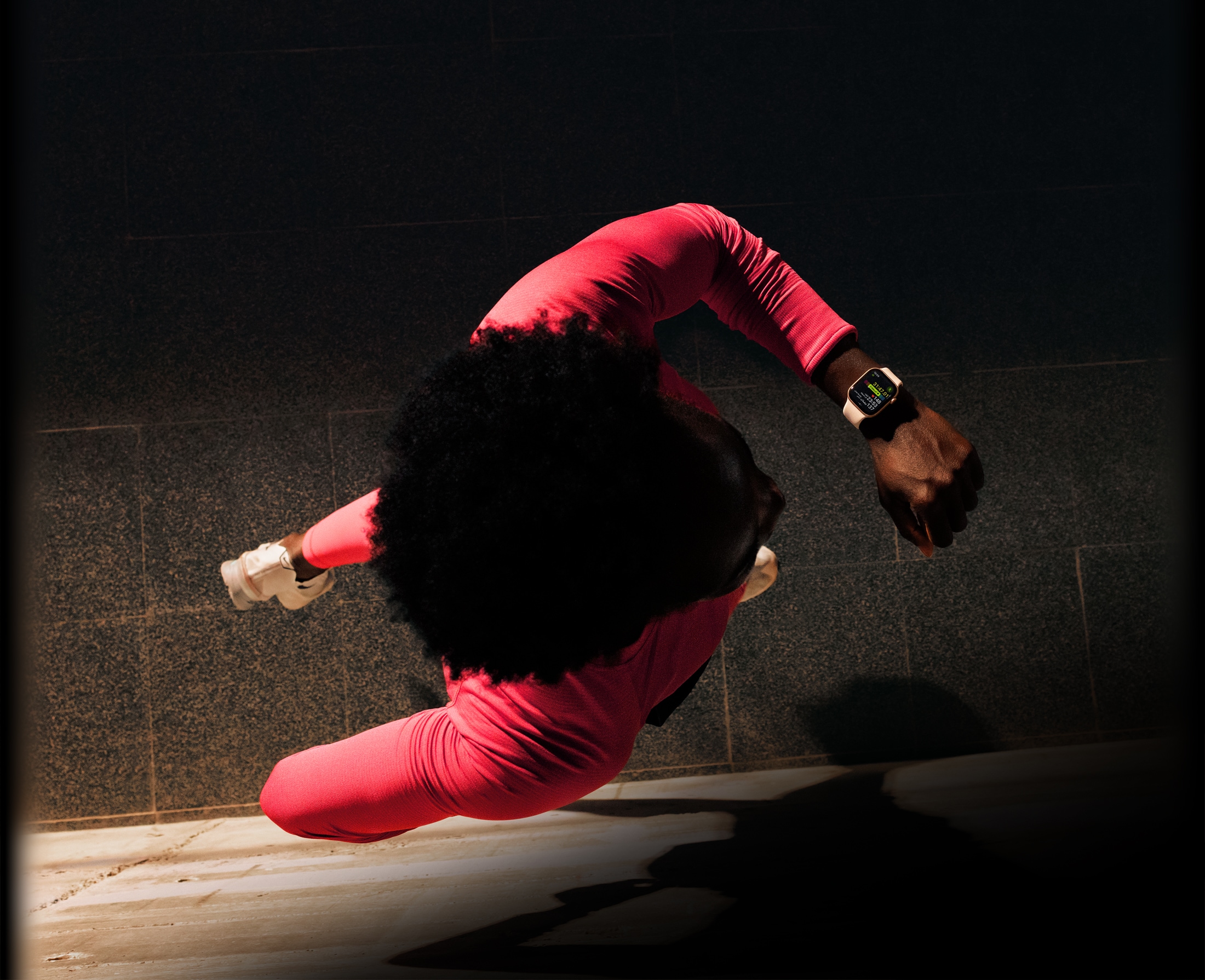 شخص يركض ويتحقق من التقدم في تطبيق التمرين على Apple Watch Series 11