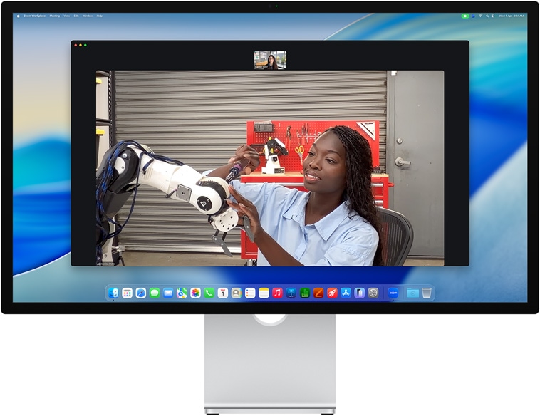 Two people on a video call on Studio Display, Center Stage keeps them centered in the frame even as one person moves to repair a piece of equipment