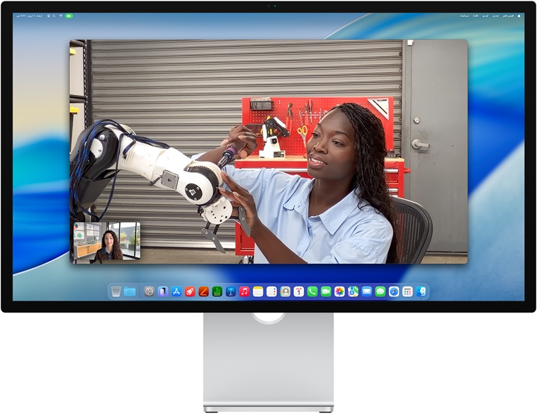 شخصان في مكالمة فيديو على شاشة Studio Display، نمط في الوسط يبقيهما في قلب الإطار أثناء تحرّك أحدهما لتصليح جهاز