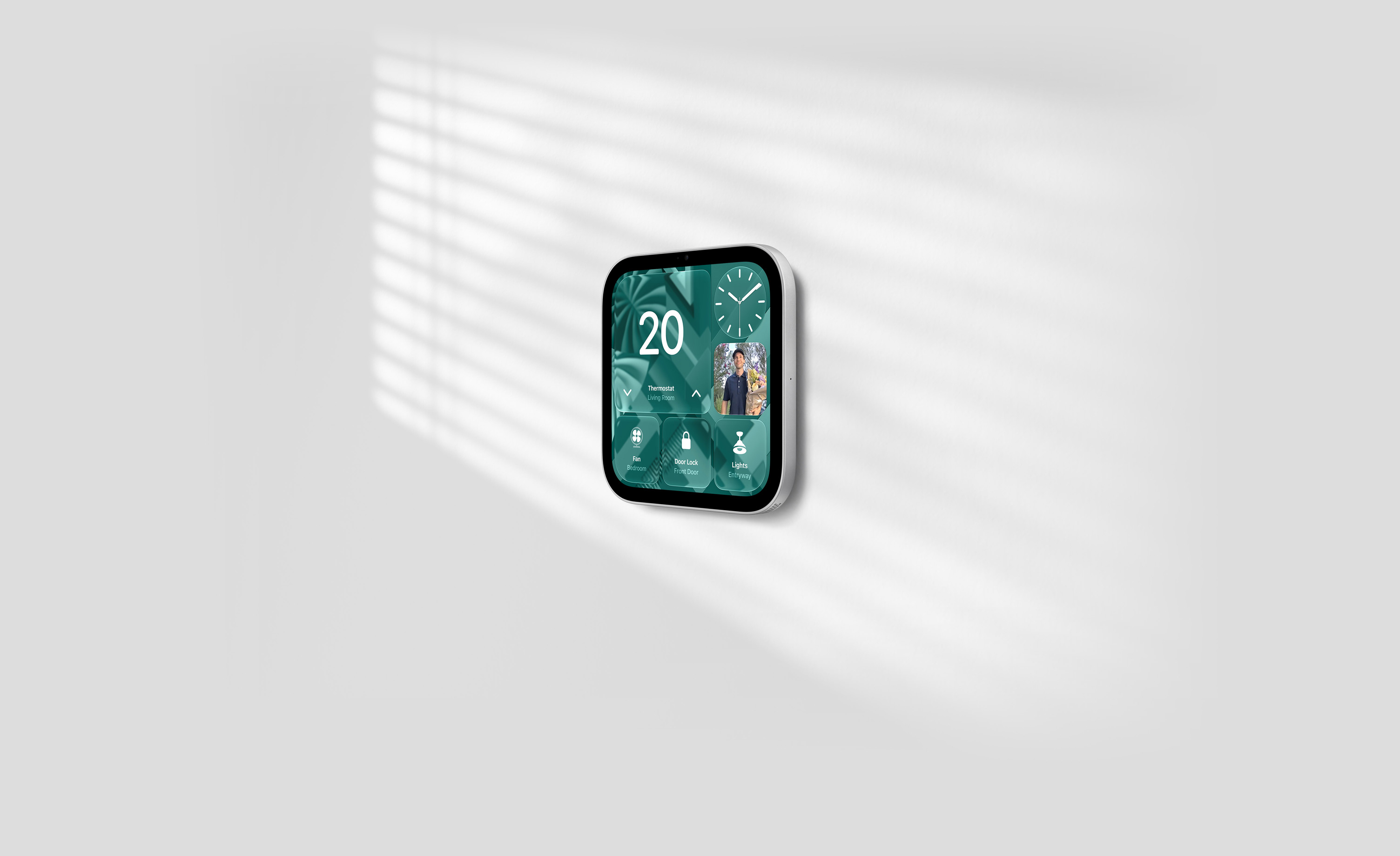 Apple HomeView, wall-mounted model on a wall, silver colour, displaying time, temperature, front door camera feed and controls for thermostat, bedroom fan, door lock and lights