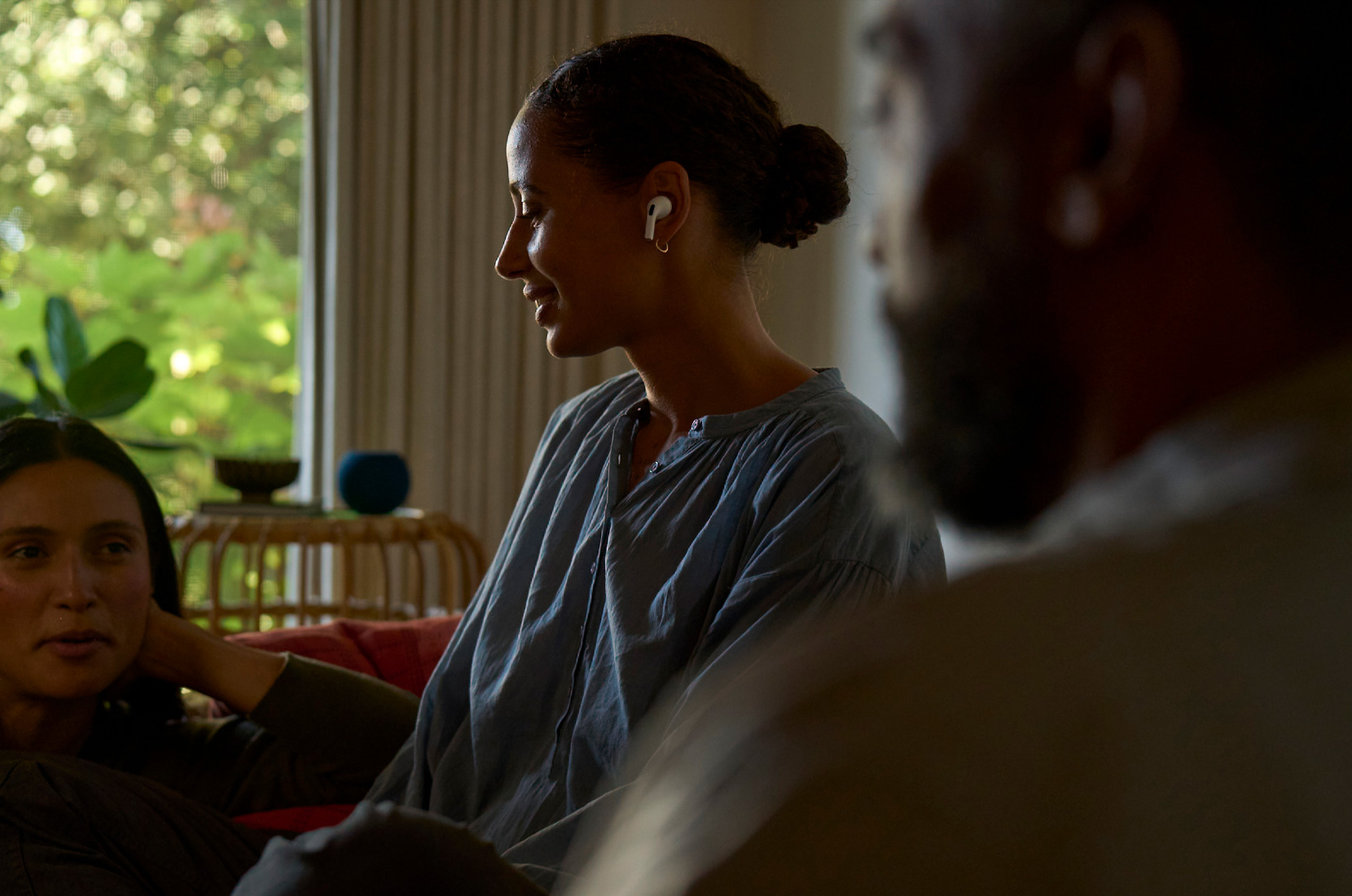 ภาพมุมมองใบหน้าหันข้างของผู้หญิงที่สวม AirPods Pro 2 ในหูด้านซ้ายและใช้คุณสมบัติสุขภาพการได้ยิน