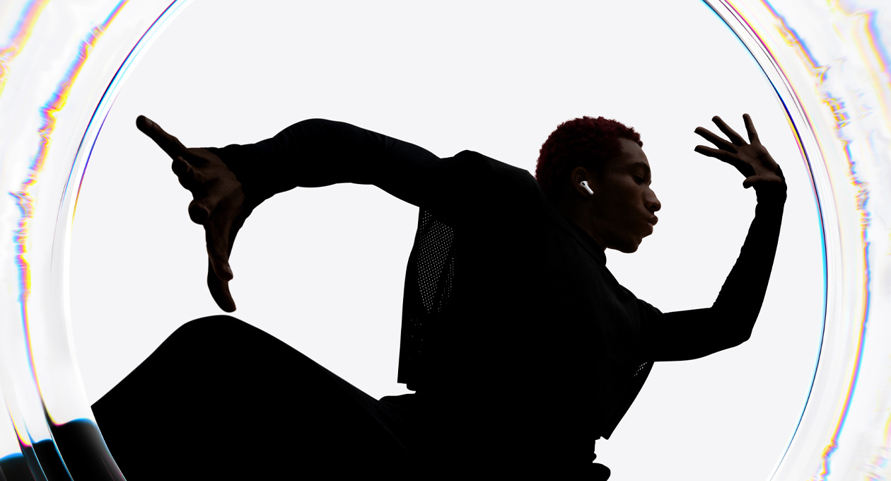 Une personne portant des AirPods Pro 3 danse sur de la musique avec les bras écartés