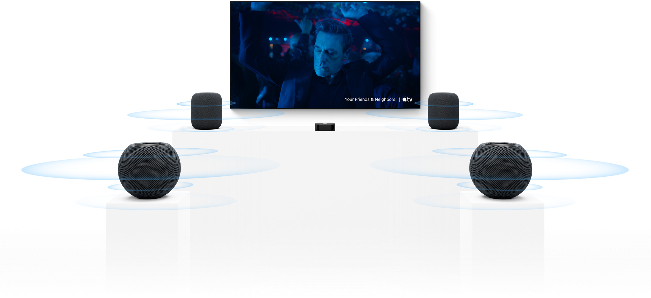 Apple TV 4K og HomePod: To HomePod-højttalere på hver side af en TV-skærm, foran dem er der to HomePod mini-højttalere, alle med lydbølger omkring sig