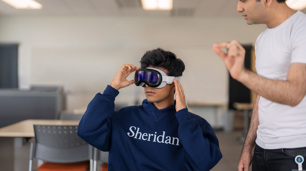 Un étudiant portant un chandail Sheridan essaie un casque de réalité mixte.