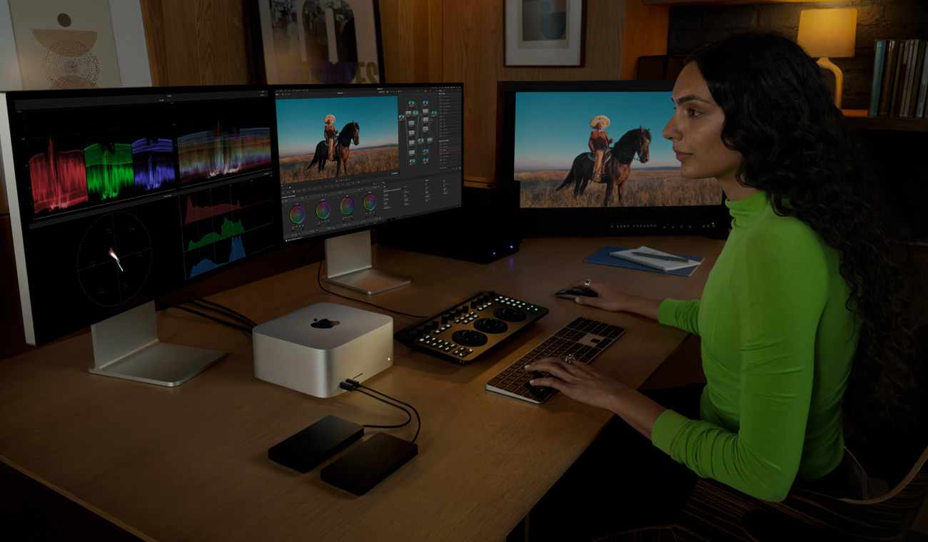 Mac Studio’ya bağlanan bir profesyonel, üç ekran kullanarak DaVinci Resolve Studio’da miksaj yapıyor