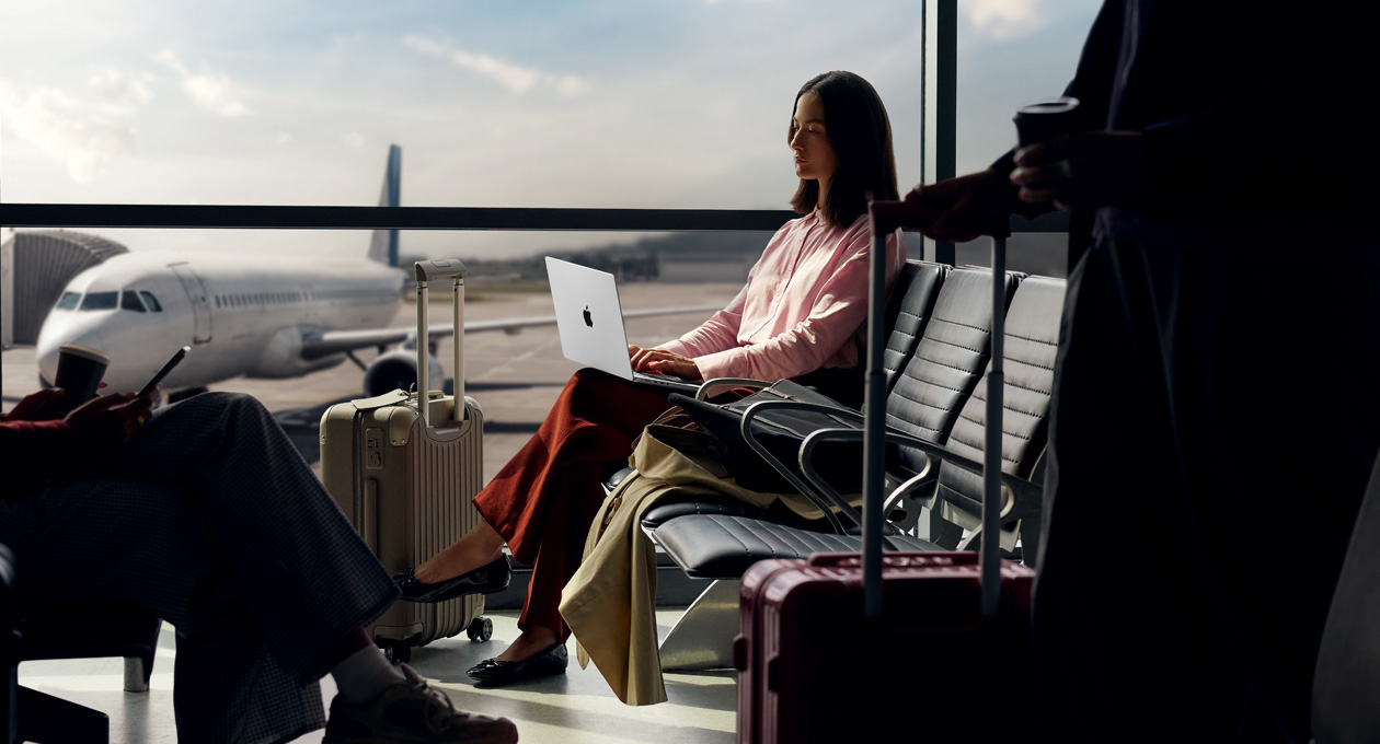 Una persona en un aeropuerto usando su MacBook Pro