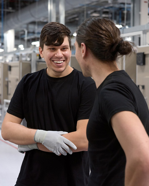 Deux employés discutent dans une usine d’assemblage d’iMac