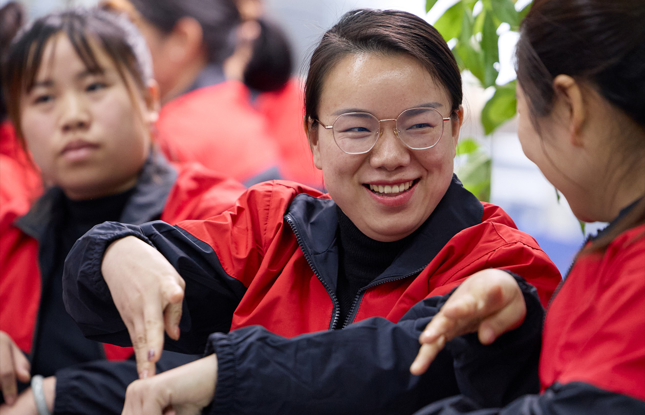 Trois personnes assises ensemble, l’une utilisant la langue des signes