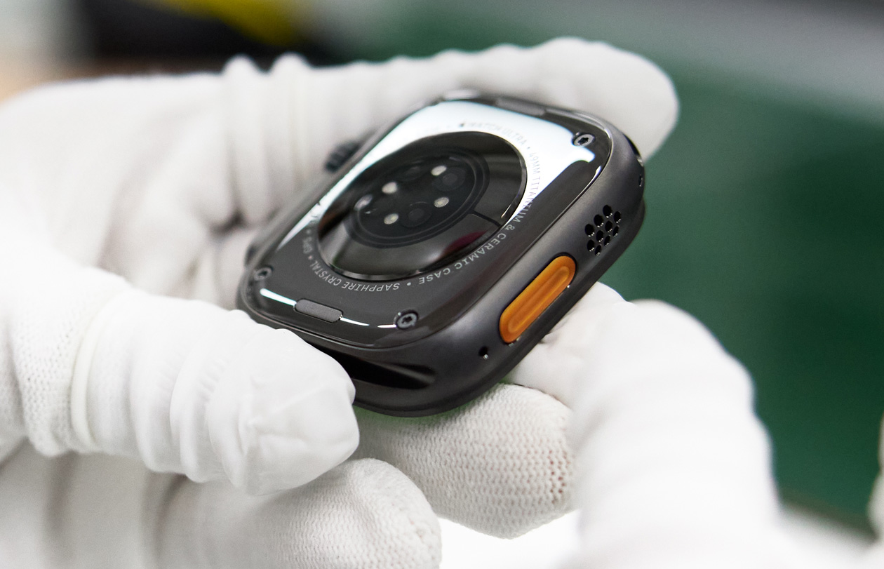 Main gantée tenant un boîtier d’Apple Watch à l’envers